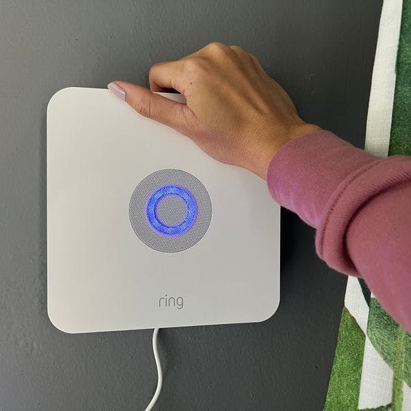 Woman installing Ring base station to her wall